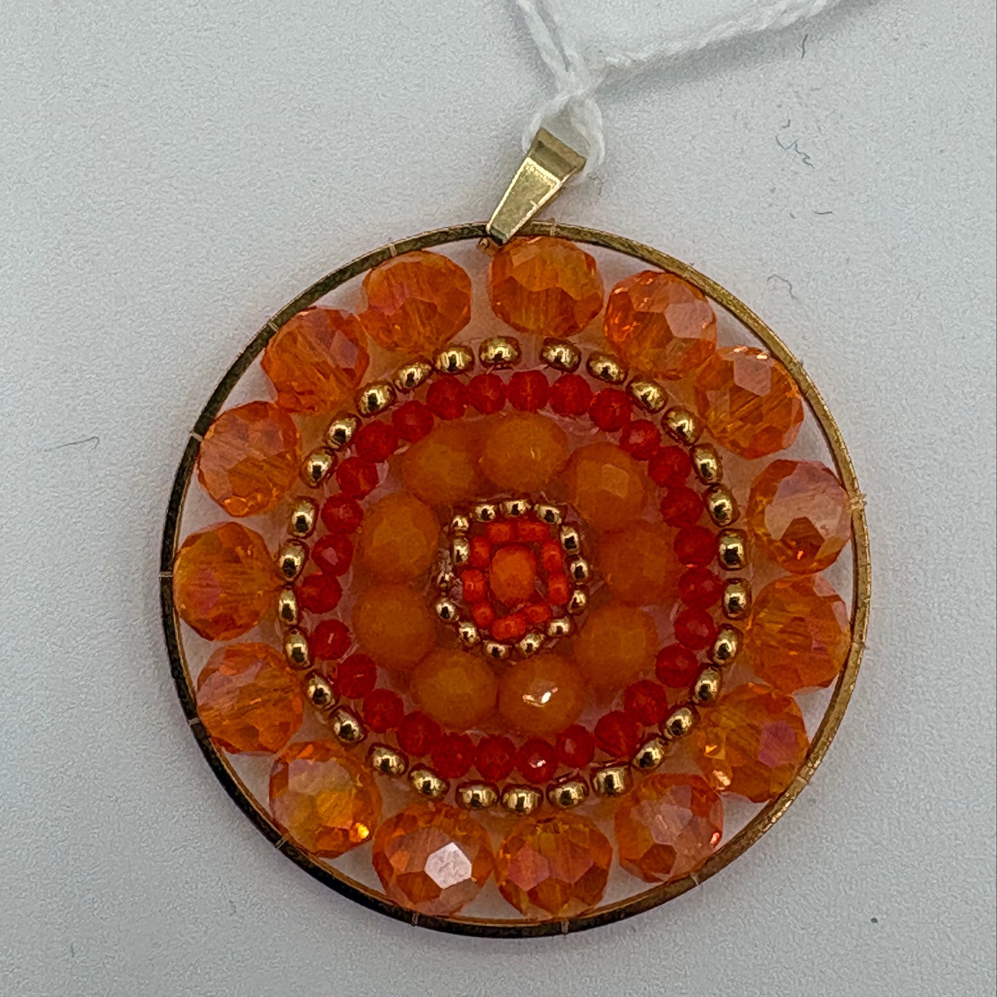Pendentif en tissage rond orange et doré